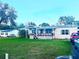 Charming single-story home featuring a covered porch, mature trees, and an expansive front yard at 11428 Pheasant Trl, Leesburg, FL 34788