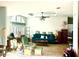 Bright living room with comfortable seating, a ceiling fan, and an eye-catching tray ceiling at 11428 Pheasant Trl, Leesburg, FL 34788