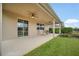 Covered back patio with a view of the landscaped backyard and lake, perfect for relaxation and enjoying the outdoors at 11579 Acosta Ave, Orlando, FL 32836