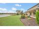 Expansive backyard with a view of a tranquil lake, featuring lush green lawn and a covered patio at 11579 Acosta Ave, Orlando, FL 32836