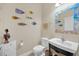 Charming powder room with fish themed décor, decorative mirror, and modern fixtures at 11579 Acosta Ave, Orlando, FL 32836
