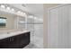 Modern bathroom featuring double sinks, sleek dark cabinets, and a glass-enclosed shower with decorative tile at 11579 Acosta Ave, Orlando, FL 32836