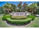 The Mabel Bridge community entrance sign is surrounded by manicured landscaping and palm trees at 11579 Acosta Ave, Orlando, FL 32836