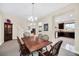 Dining room features a wood table with seating for six, neutral walls, and open layout to the kitchen at 11579 Acosta Ave, Orlando, FL 32836
