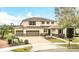 A charming front view of a two-story home showcasing a three-car garage and lovely landscaping at 11579 Acosta Ave, Orlando, FL 32836