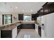 Kitchen features dark wood cabinets, stainless steel appliances, granite countertops, and tiled flooring at 11579 Acosta Ave, Orlando, FL 32836