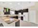 Kitchen features dark wood cabinets, stainless steel appliances, granite countertops, and bar seating at 11579 Acosta Ave, Orlando, FL 32836