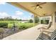 Covered patio with ceiling fans offering scenic views of a lush lawn and tranquil lake, ideal for outdoor living at 11579 Acosta Ave, Orlando, FL 32836