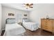 Charming bedroom featuring twin beds, plantation shutters, and hardwood floors at 12199 Se 175Th Loop, Summerfield, FL 34491