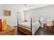 Bright bedroom with wood floors, plantation shutters, a four-poster bed, and access to the en-suite bathroom at 12199 Se 175Th Loop, Summerfield, FL 34491