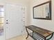 Inviting entryway with tiled floor, white paneled door with decorative glass and a slate-topped console table with mirror at 12199 Se 175Th Loop, Summerfield, FL 34491