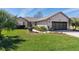 Well-kept lawn, manicured landscaping, and stylish garage door highlight this attractive home's exterior at 12199 Se 175Th Loop, Summerfield, FL 34491
