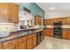Modern kitchen with wooden cabinetry, stainless steel appliances, under cabinet lighting, and decorative accents at 12199 Se 175Th Loop, Summerfield, FL 34491