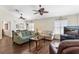 Cozy living room with hardwood floors, ceiling fans, and comfortable seating near bright windows at 12199 Se 175Th Loop, Summerfield, FL 34491