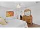 A light filled main bedroom with wooden floors, ceiling fan, and view into the dining room at 12199 Se 175Th Loop, Summerfield, FL 34491