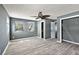 Bedroom featuring wood-look flooring, ceiling fan, multiple windows, and en-suite bathroom at 1301 N Shore Dr, Leesburg, FL 34748