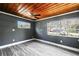 Bedroom with wood-look flooring, painted walls, two windows for natural light, and unique wood ceiling at 1301 N Shore Dr, Leesburg, FL 34748