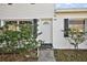 View of the front door with a white exterior, black shutters, and a stone walkway at 1301 N Shore Dr, Leesburg, FL 34748