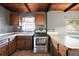 Kitchen with wood cabinets, tile floors, stainless steel oven, and breakfast bar at 1301 N Shore Dr, Leesburg, FL 34748