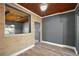 Open living space with brick accent wall, wood-look flooring, ceiling fan, and warm wood ceiling at 1301 N Shore Dr, Leesburg, FL 34748