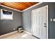 Cozy mud room features warm wood plank ceiling, cool gray walls, and classic tile flooring at 1301 N Shore Dr, Leesburg, FL 34748