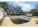 In-ground pool surrounded by a concrete patio and a view of the home's rear at 1301 N Shore Dr, Leesburg, FL 34748