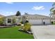 Beautiful home exterior with a well-manicured lawn, mature landscaping, and a spacious three-car garage at 1367 Honea Path, The Villages, FL 32162
