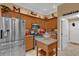 Well-lit kitchen with stainless steel appliances, custom wood cabinets, and stylish backsplash at 1367 Honea Path, The Villages, FL 32162