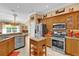 Kitchen featuring stainless steel appliances, custom oak cabinets, and a view of the dining area at 1367 Honea Path, The Villages, FL 32162