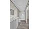 Bright bathroom with white cabinets, mirror, shower-tub combo, and modern floors at 147 Woodstork Way, Frostproof, FL 33843
