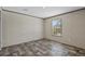 Bright bedroom features a window and gray wood-look flooring at 147 Woodstork Way, Frostproof, FL 33843