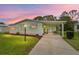 Inviting home exterior with a covered carport and a cozy front entrance at dusk at 1507 E Schwartz Blvd, Lady Lake, FL 32159