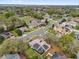 Aerial shot of a neighborhood featuring well-maintained homes with lush landscaping and tree-lined streets at 1602 Oak Hollow Rd, Clermont, FL 34711