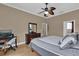 Bedroom with light wood floors, an office desk, dresser with mirror, and access to the bathroom at 1602 Oak Hollow Rd, Clermont, FL 34711