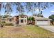 Charming, peach-colored two-story home with a two-car garage and mature landscaping at 1602 Oak Hollow Rd, Clermont, FL 34711