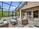 Screened patio featuring comfortable seating and views of the backyard at 1602 Oak Hollow Rd, Clermont, FL 34711