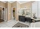 Bathroom with white tile floors features a toilet room, a large vanity and ample lighting at 17126 Se 117Th Cir, Summerfield, FL 34491