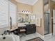 Elegant bathroom boasts black cabinets, makeup vanity and a glass-enclosed shower at 17126 Se 117Th Cir, Summerfield, FL 34491
