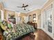 Spacious bedroom featuring hardwood floors, ceiling fan, with decorative trim and french door access at 17126 Se 117Th Cir, Summerfield, FL 34491