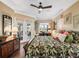 Cozy bedroom boasts hardwood floors, ceiling fan, and access to the outdoors at 17126 Se 117Th Cir, Summerfield, FL 34491