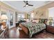 Well-lit bedroom with a ceiling fan, hardwood floors, and french doors leading to the backyard at 17126 Se 117Th Cir, Summerfield, FL 34491
