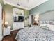 Bedroom with a green accent wall with built-ins and a television at 17126 Se 117Th Cir, Summerfield, FL 34491