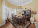 Dining room featuring hardwood floors, a modern chandelier, large windows and decorative accents at 17126 Se 117Th Cir, Summerfield, FL 34491