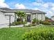 Close-up of a well-manicured front yard with lush plantings, paver walkway and healthy, green grass at 17126 Se 117Th Cir, Summerfield, FL 34491