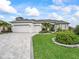 Charming home featuring a three-car garage, paver driveway, and lush landscaping enhancing its curb appeal at 17126 Se 117Th Cir, Summerfield, FL 34491