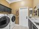 Laundry room with a washer, dryer, and sleek cabinetry at 17126 Se 117Th Cir, Summerfield, FL 34491