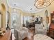 Open living area with beautiful flooring, chandeliers, decorative chairs, and access to the dining room and front door at 17126 Se 117Th Cir, Summerfield, FL 34491