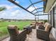 Covered outdoor patio space with seating and fire table overlooking the lawn at 17126 Se 117Th Cir, Summerfield, FL 34491
