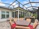 Covered patio with brick floors, outdoor dining set, and screened in porch at 17126 Se 117Th Cir, Summerfield, FL 34491