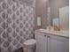Well-maintained bathroom featuring a vanity with gold fixtures and a patterned shower curtain at 17694 Se 88Th Covington Cir, The Villages, FL 32162